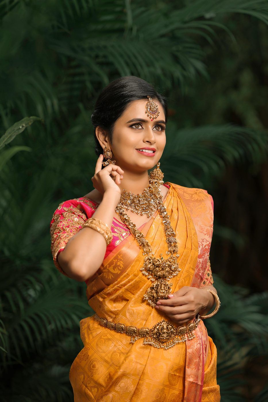 Model in a mustard traditional silk saree with temple jewellery
